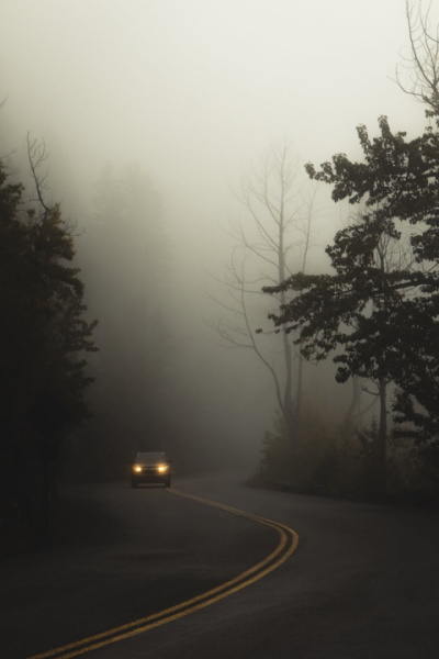 Car driving on the road against misty sky